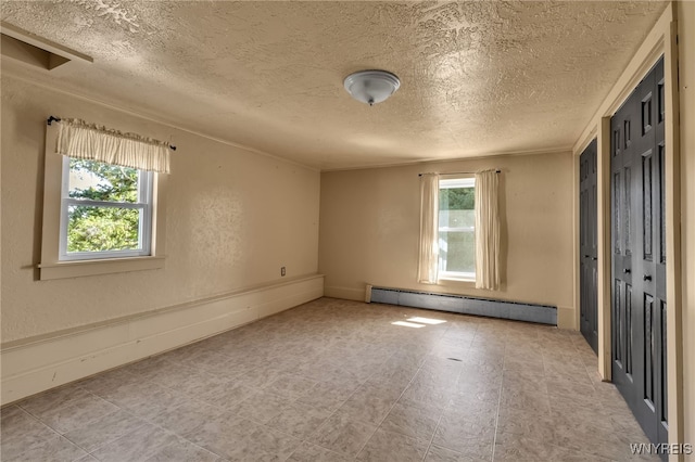 empty room featuring a baseboard radiator and a textured ceiling