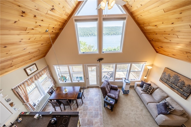 carpeted living room featuring a water view, a wealth of natural light, and wood ceiling