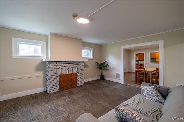 carpeted living room featuring a wealth of natural light, ornamental molding, and a brick fireplace