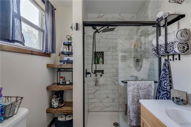 bathroom with vanity, toilet, and a shower with door