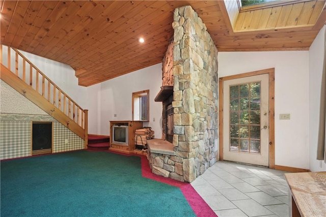 unfurnished living room featuring vaulted ceiling, wooden ceiling, baseboards, a fireplace, and stairs