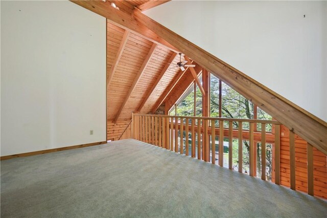 additional living space featuring vaulted ceiling with beams, baseboards, a ceiling fan, wood ceiling, and carpet floors