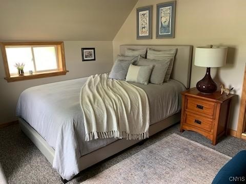 bedroom with light carpet and lofted ceiling