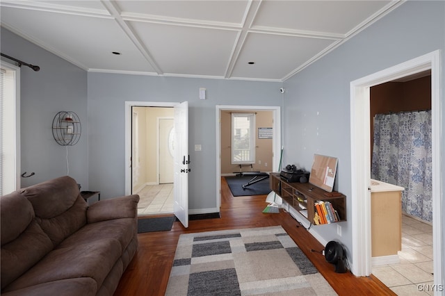 living room featuring coffered ceiling, wood-type flooring, and crown molding