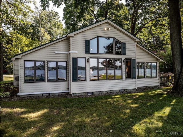 rear view of property featuring a lawn