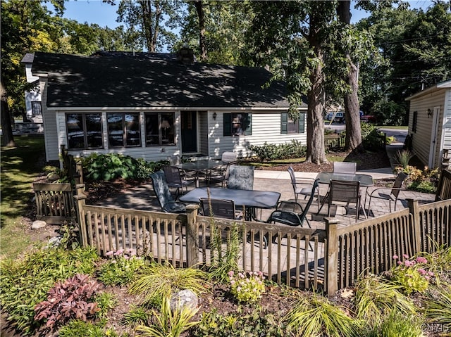 back of property with a wooden deck, a patio area, and a fire pit