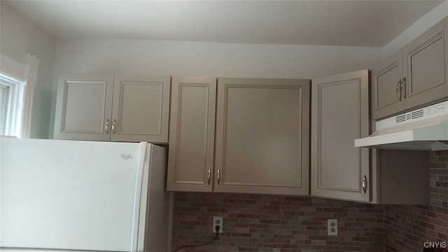 kitchen featuring gray cabinets, decorative backsplash, and white fridge