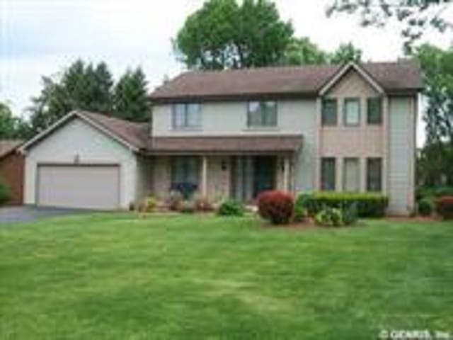 view of property featuring a garage and a front yard