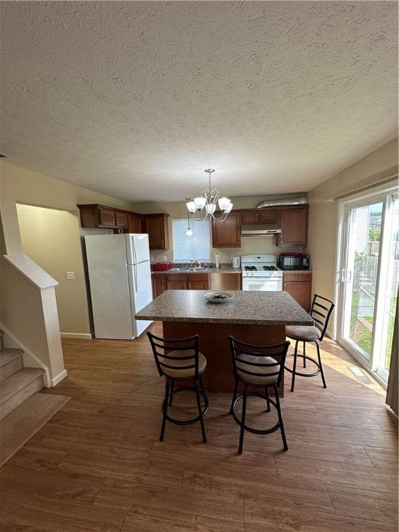 dining room with hardwood / wood-style floors, a notable chandelier, and a textured ceiling