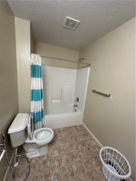 bathroom featuring a textured ceiling, toilet, and shower / bathtub combination with curtain