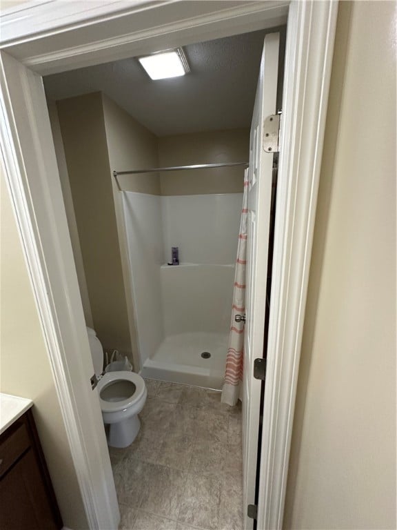 bathroom featuring vanity, toilet, and a shower with curtain