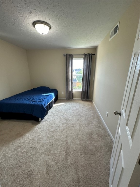 bedroom with a textured ceiling and carpet flooring