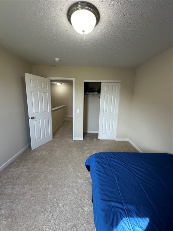 unfurnished bedroom with carpet, a textured ceiling, and a closet