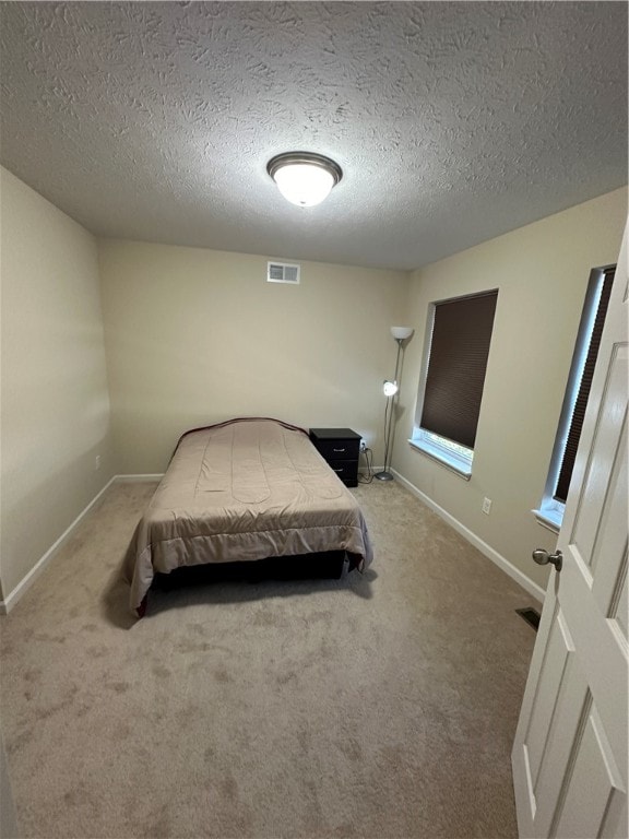 carpeted bedroom with a textured ceiling