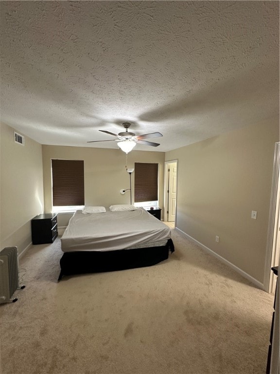 unfurnished bedroom with light carpet, a textured ceiling, and ceiling fan