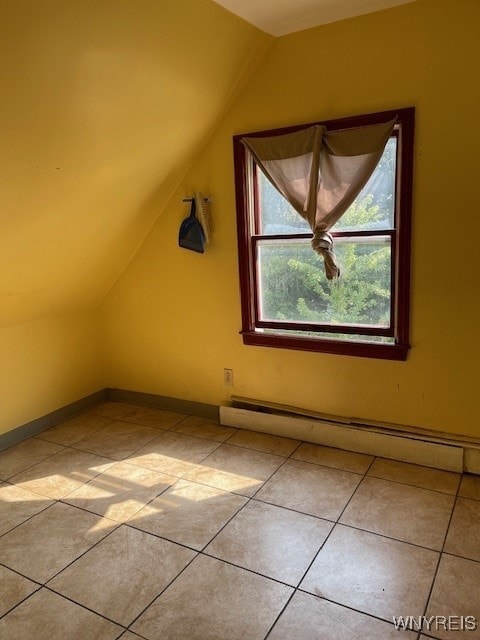 bonus room featuring baseboard heating, light tile patterned floors, and lofted ceiling