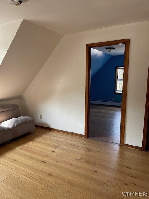 bonus room with light hardwood / wood-style flooring, lofted ceiling, and baseboard heating