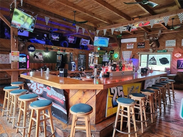 bar featuring wooden ceiling, hardwood / wood-style floors, wooden counters, wood walls, and ceiling fan