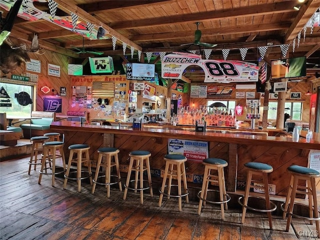 bar with wood walls, hardwood / wood-style floors, beam ceiling, and wooden ceiling