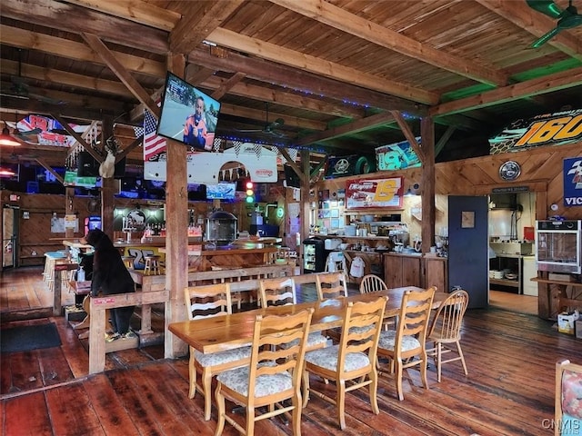 dining room featuring hardwood / wood-style floors, ceiling fan, and wooden walls