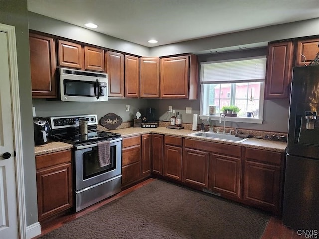 kitchen with stainless steel appliances, dark hardwood / wood-style flooring, and sink