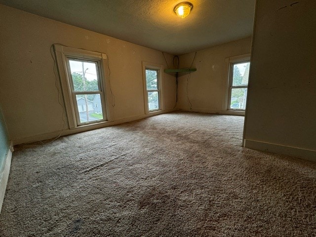 spare room with a textured ceiling and carpet