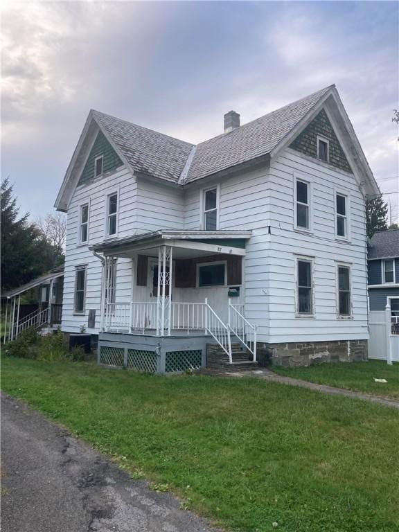 87 Canasawacta St, Norwich-City, NY 13815 - view of front of house featuring a chimney, a porch, and a front lawn