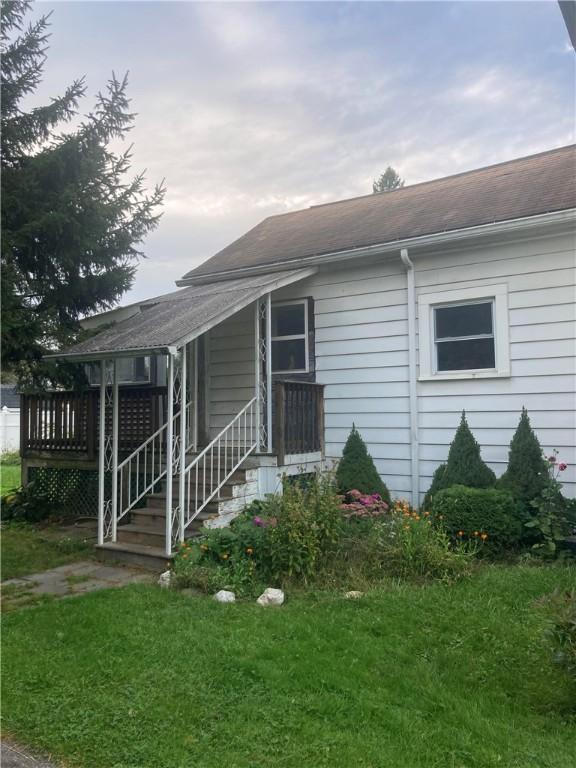 87 Canasawacta St, Norwich-City, NY 13815 - view of front of home featuring a wooden deck, a shingled roof, and a front lawn