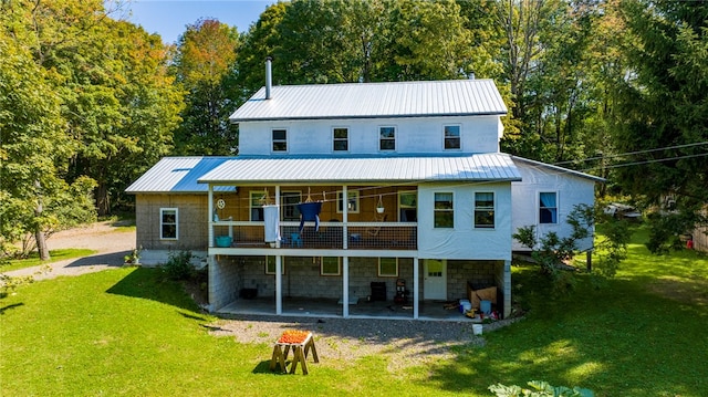 rear view of house with a lawn and a patio