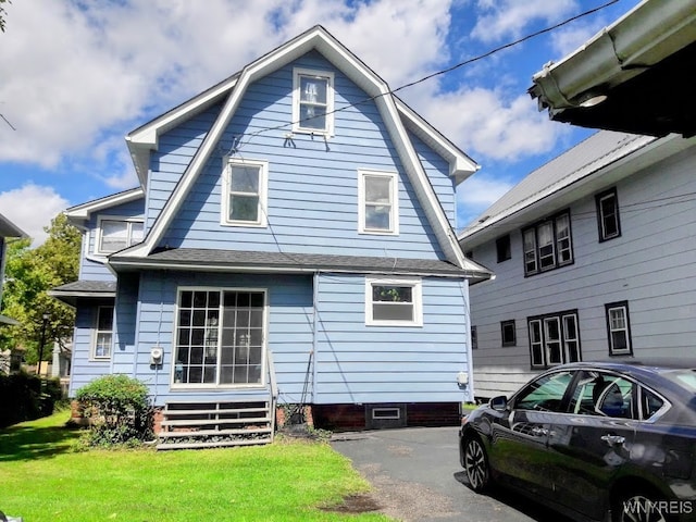 rear view of house featuring a yard