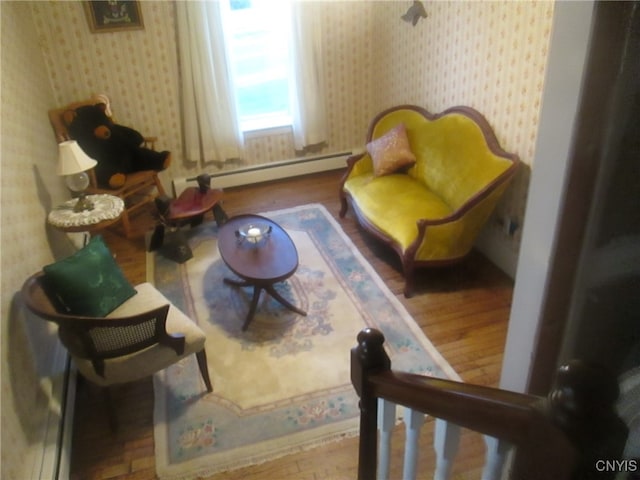 living area with wood-type flooring and a baseboard radiator