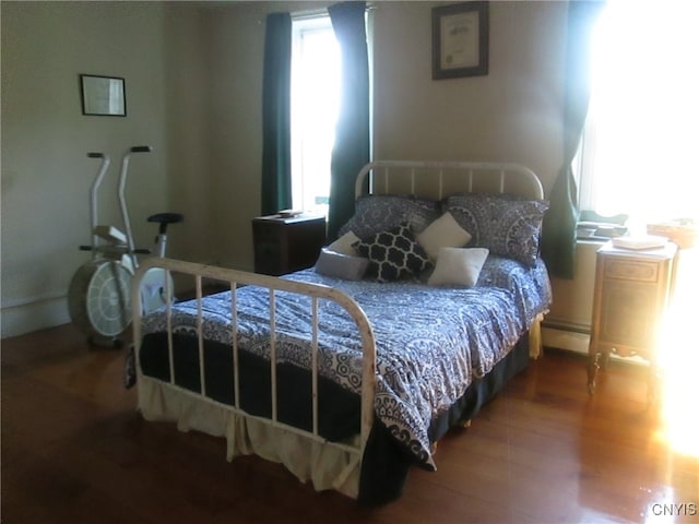 bedroom featuring baseboard heating and hardwood / wood-style floors