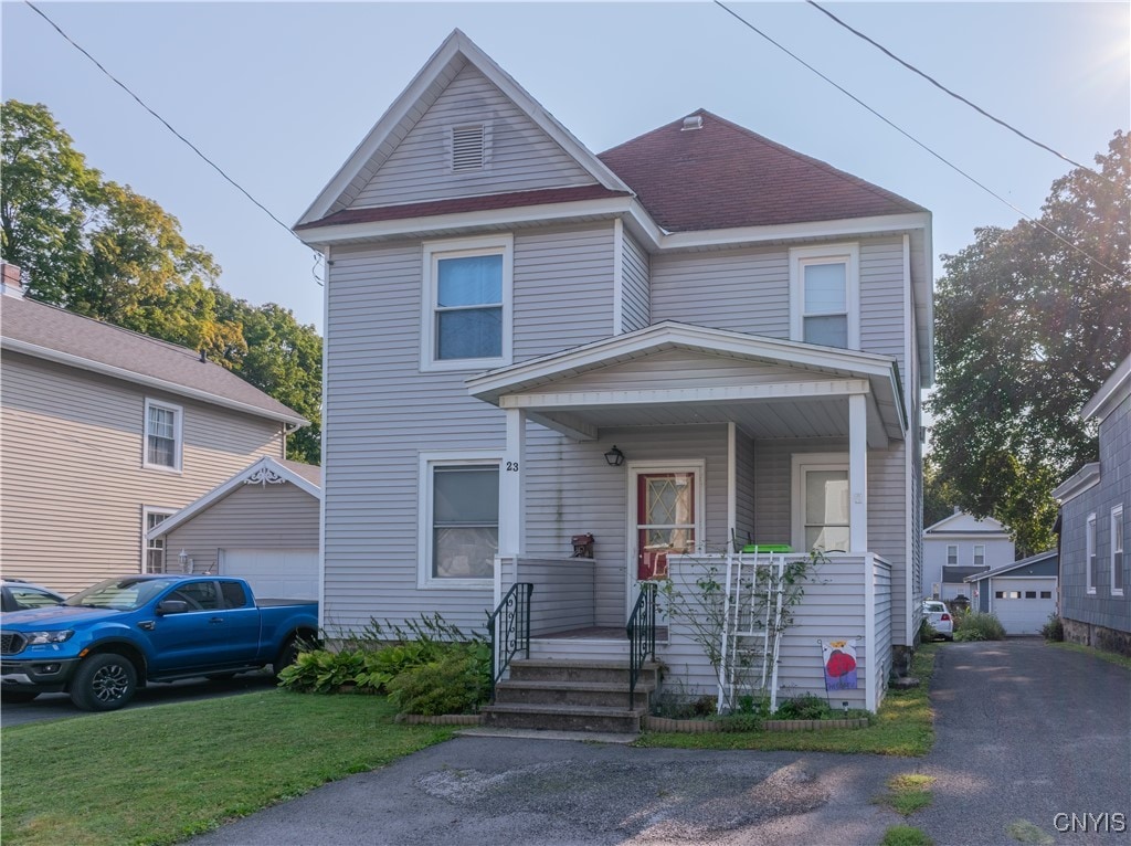 view of property with a garage and covered porch