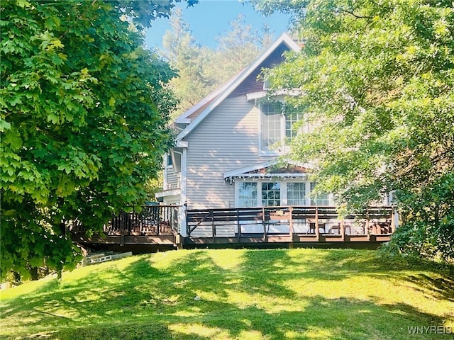 back of property featuring a lawn and a deck