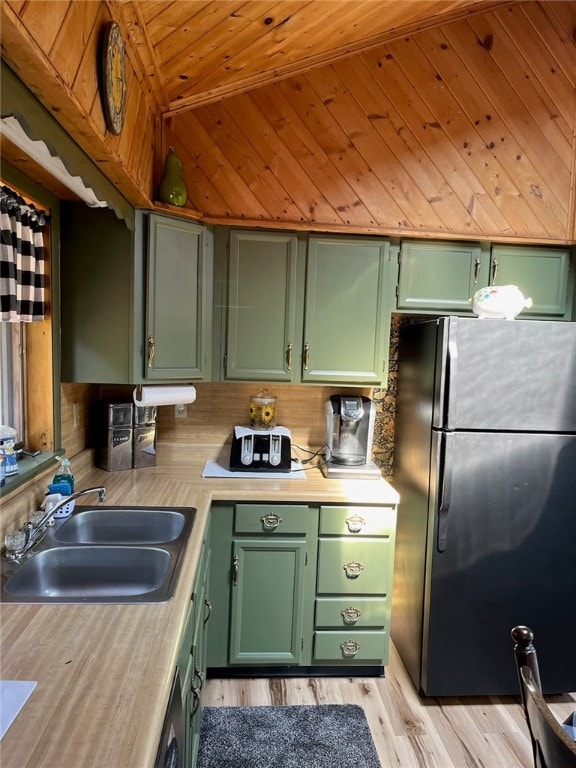 kitchen with green cabinets, sink, stainless steel fridge, and wooden ceiling