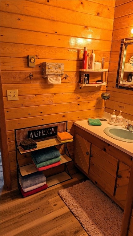 bathroom with vanity, hardwood / wood-style floors, and wood walls