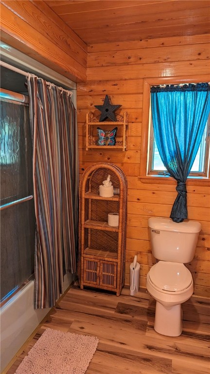 bathroom with plenty of natural light, toilet, hardwood / wood-style flooring, and shower / bath combo