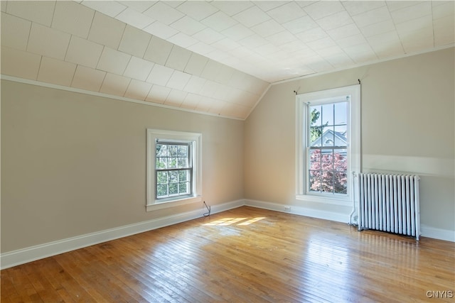 bonus room with lofted ceiling, light wood-type flooring, and radiator