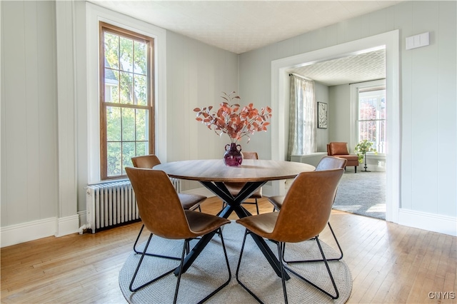 dining space featuring light hardwood / wood-style floors and radiator heating unit