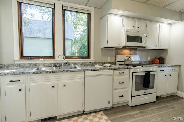 kitchen featuring white cabinets, sink, light wood-type flooring, and white appliances