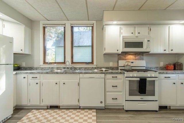 kitchen featuring sink, white cabinetry, light wood-type flooring, and white appliances