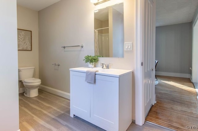 bathroom with vanity, curtained shower, wood-type flooring, and toilet