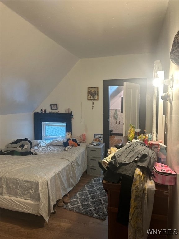 bedroom featuring vaulted ceiling and hardwood / wood-style flooring