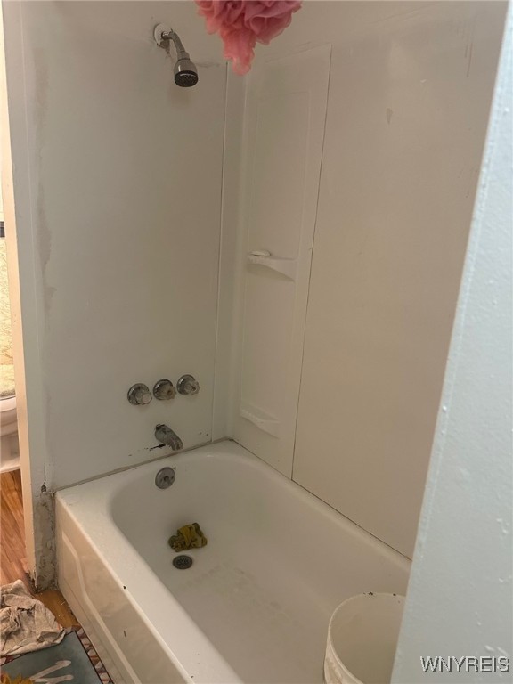 bathroom featuring washtub / shower combination and toilet