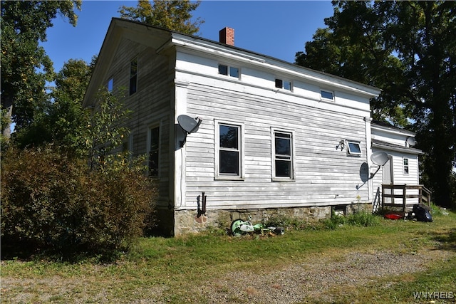 view of side of home with a yard