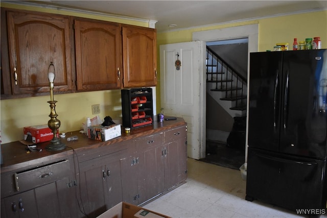 kitchen with black fridge and crown molding