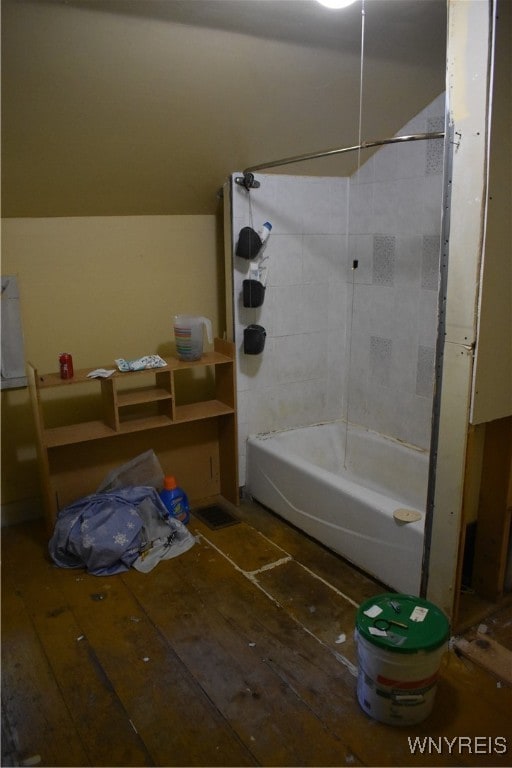 bathroom featuring wood-type flooring and tiled shower / bath