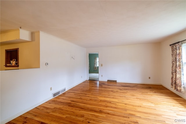 unfurnished room featuring crown molding and light hardwood / wood-style floors