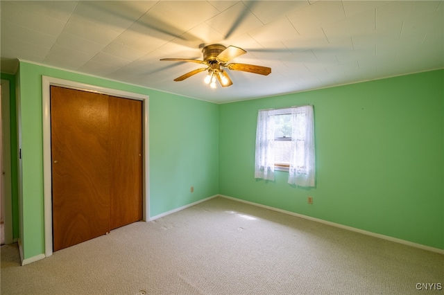 unfurnished bedroom featuring ceiling fan, light colored carpet, and a closet