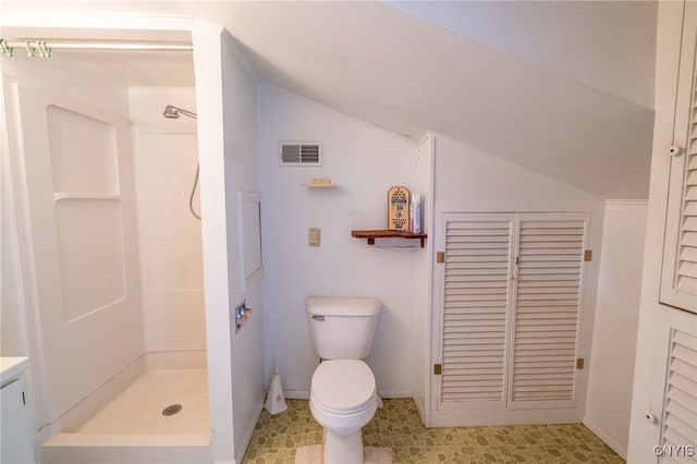 bathroom featuring a shower, vaulted ceiling, toilet, and vanity